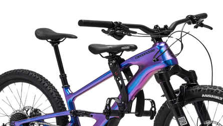 Purple and blue mountain bike with full suspension and knobby tires.